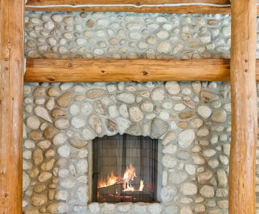 River-stone fireplace framed by hand-hewn logs